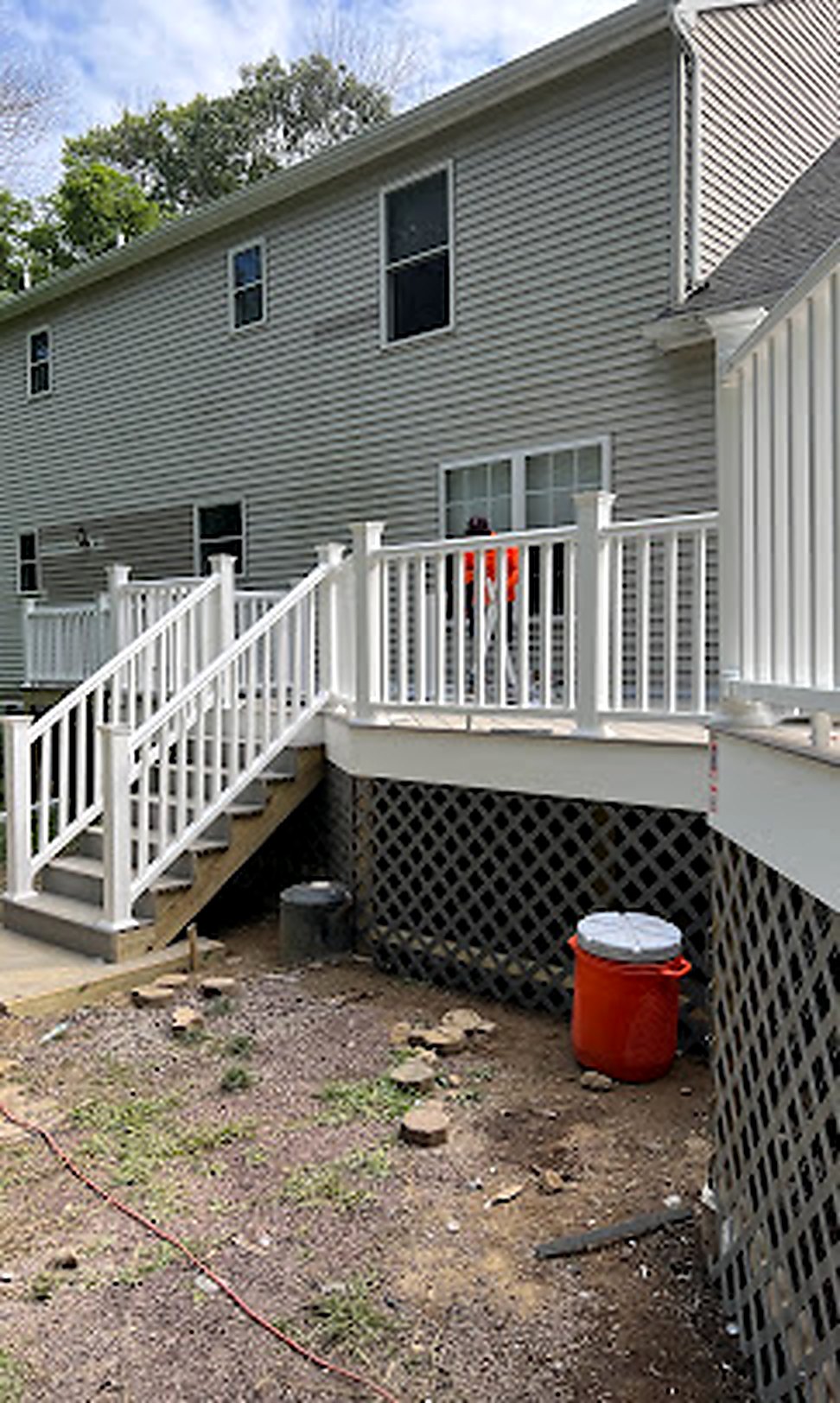 Finished white deck railing with lattice in afternoon sun
